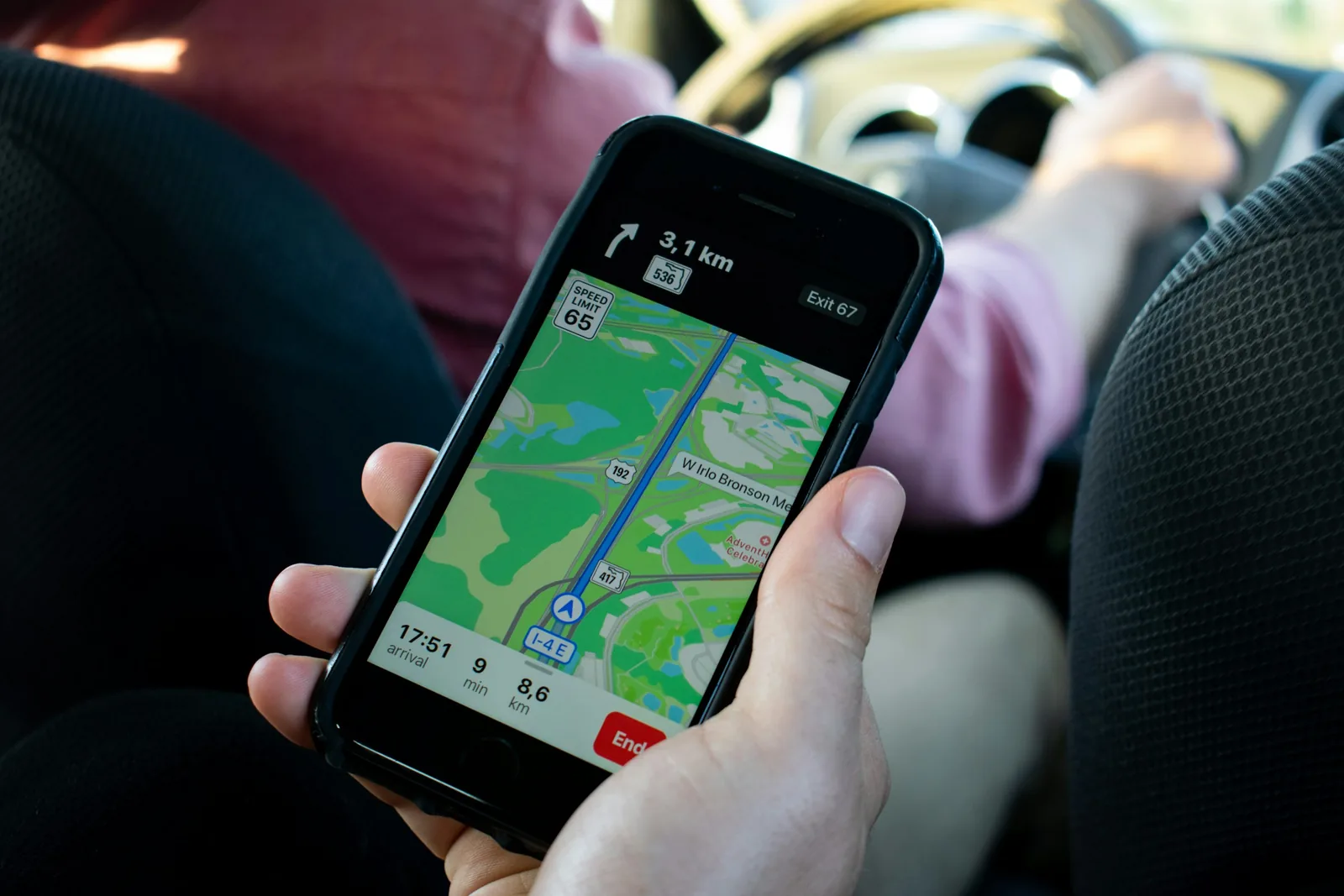 A phone mounted in a vehicle showing turn-by-turn navigation on a map